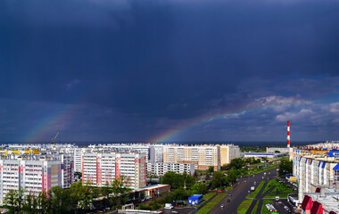 Double rainbow over city buildings after rain