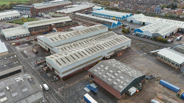 Aerial view of industrial buildings stretching into the distance under a muted sky, the roofs reflecting the diffused light, Loughborough, England, United Kingdom.