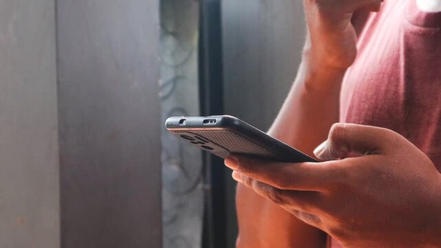 Asian man is typing on a smartphone secretly in the corner