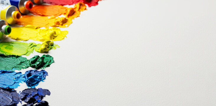 Artist tools and colorful paint swatches on white background. Creative art concept. Vibrant painting supplies for hobby and education. copy space