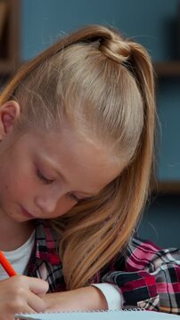 Caucasian girl kid focused busy daughter child drawing with color pencils at evening home at desk draw picture art therapy learning studying create homework education childish imagination childhood