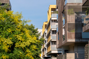 Modern architecture housing in Montpellier France displaying a layered facade with balconies, surrounding vegetation, afternoon light and a clear urban pattern