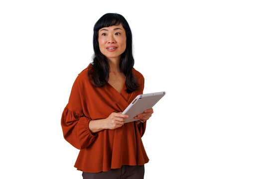 Asian professional woman reviewing information on her tablet, thinking about innovative business strategies and technology