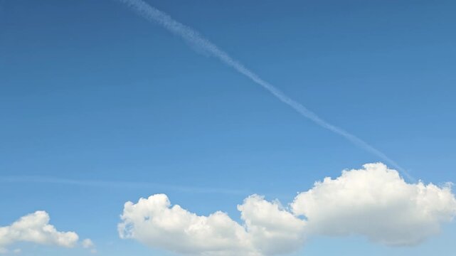 Cloudscape, a Timelapse of a beautiful Blue sky with drifting clouds and a subtle contrail background