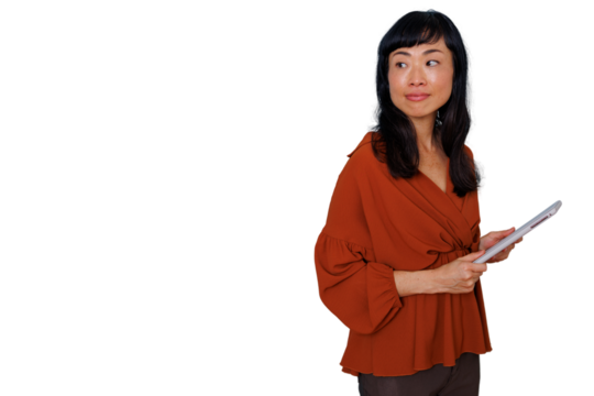 Asian business woman holding a digital tablet with both hands, looking away and thinking. Professional female worker or manager