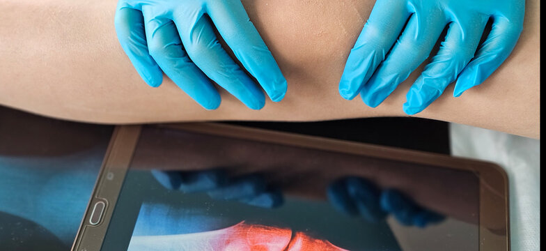 Doctor Examining Patients Knee With X-Ray Image - Powered by Adobe