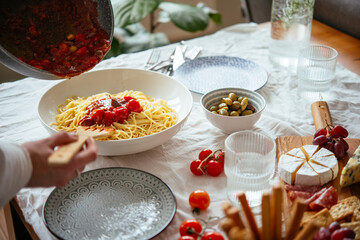Friends having a pasta dinner with wine at home.