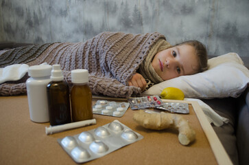 A little girl is lying in bed sick. The concept of illness, cold, acute respiratory viral infection