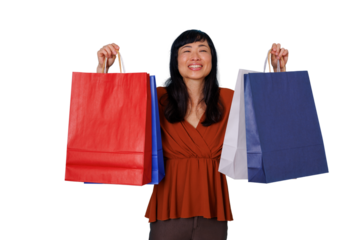 Woman smiling happily after successful shopping spree, holding colorful bags on transparent background