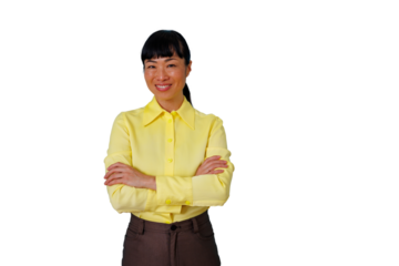 Confident asian businesswoman smiling at camera, standing with arms crossed, dressed in yellow shirt, symbolizing professional success