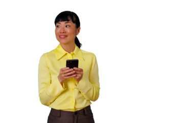 Asian businesswoman in a yellow shirt holding a smartphone, social networking or texting, smiling while looking away
