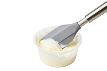 Silicone spatula scooping thick sour cream from a container on a transparent background