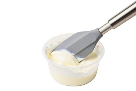Silicone spatula scooping thick sour cream from a container on a transparent background