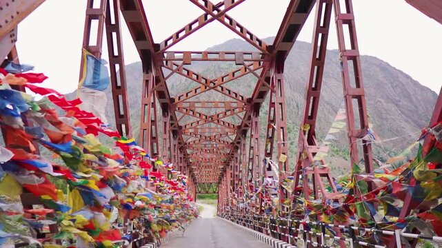 Buddhist prayer flags on metal suspension bridge at Lahaul, Himachal Pradesh, India. Colorful flags spreading good vibes and Buddhist prayers. Travel and vacation background.