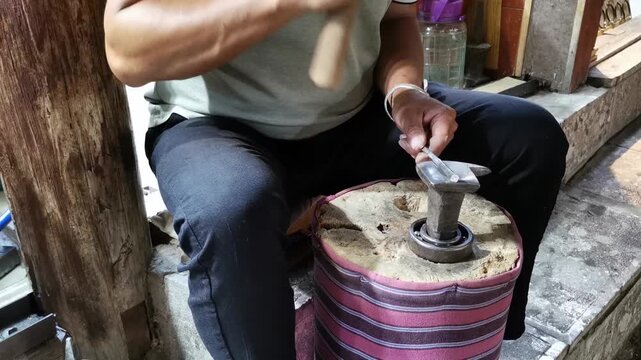 Traditional Silversmith Crafting Handmade Silver Jewelry with Hammer and Anvil in Artisan Workshop