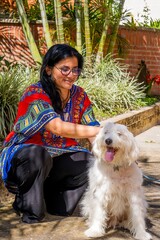 A woman is petting a white dog