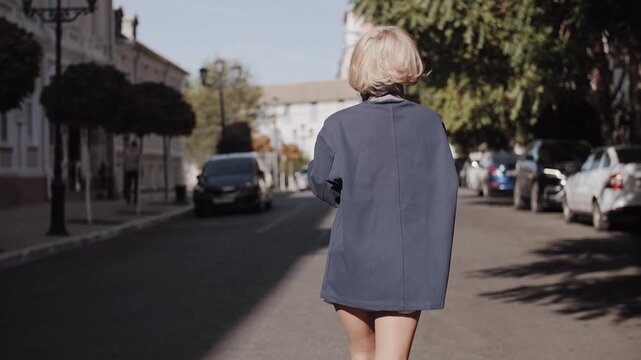 Blonde Woman Walking Away in Blue Jacket