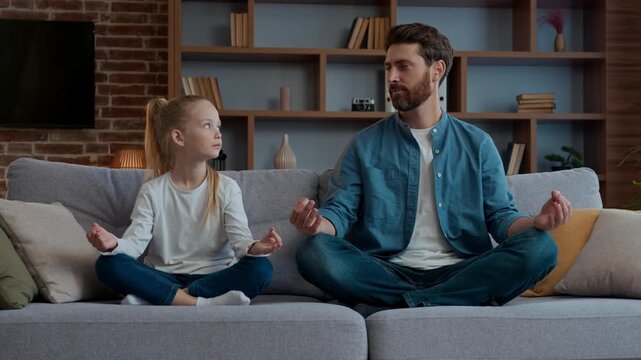 Caucasian family mindfulness meditate father with little girl kid in living room with closed eyes meditating dad with daughter child in lotus position tranquil control mind wellness harmony balance
