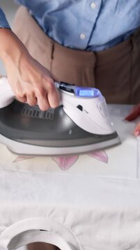 Woman Doing T Shirt Print Transfer Using Iron Appliance
