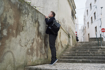 A Curious Young Man Peeking into Someone Yard Through the Fence