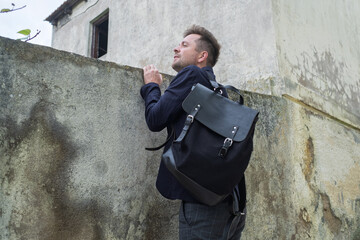 A Curious Young Man Peeking into Someone Yard Through the Fence