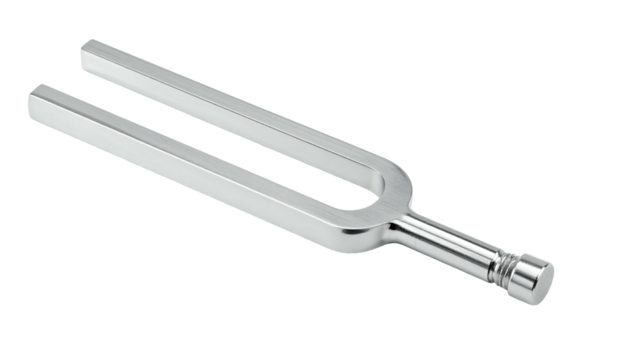 Silver metal tuning fork against a stark black background