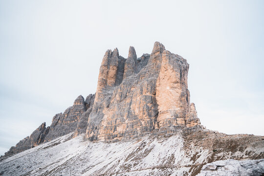 View of rugged, imposing rock formations rise against the sky, dusted with snow, creating a stark contrast between stone and winter, Auronzo di Cadore, Province of Belluno, Italy.