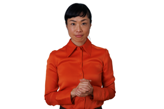 Asian businesswoman with attentive expression standing, ready to listen or present, hands clasped, transparent background