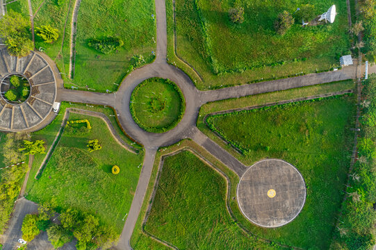 Aerial view of the circular patterns and radial pathways create a mesmerizing dance of green and concrete, contrasting with the surrounding lush landscape, Abuja, abuja, Nigeria.