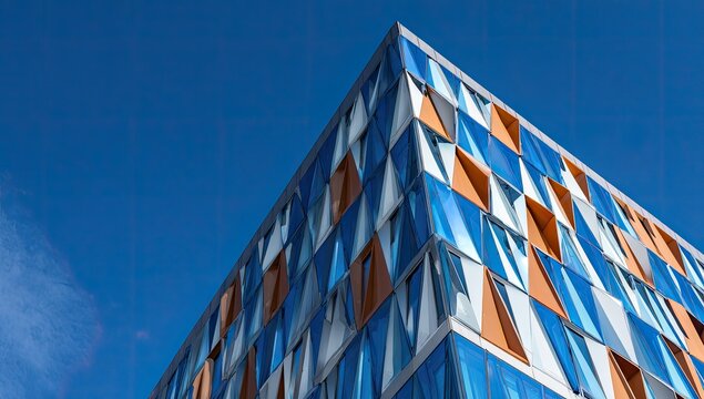 Angular architecture with geometric windows on a modern high-rise building against a blue sky