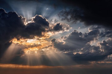 Dramatic sky with sunlight bursting through dark, layered clouds, creating striking beams of light