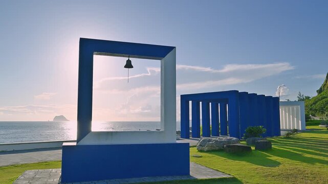 Wangli Happiness Square on a bright sunny autumn morning in New Taipei City Taiwan The sun creates a starburst effect through the blue and white frame art toward Keelung Islet.