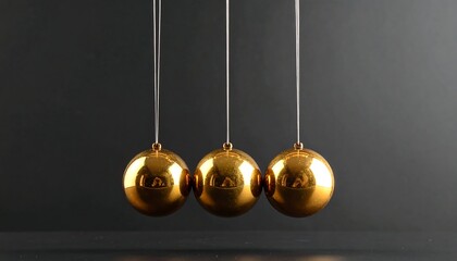 Three golden spheres hanging from strings, evenly spaced, against a dark gray background, capturing motion and reflection
