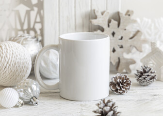 White blank coffee mug near wooden Christmas decor and baubles closeup, mockup