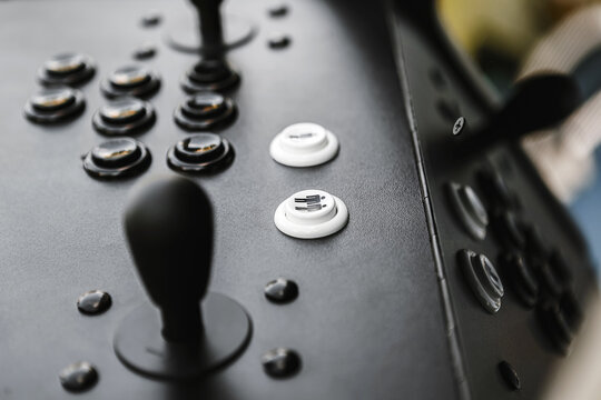 Arcade joystick and buttons close-up on retro game machine control panel.