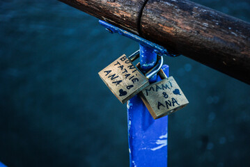 a pair of dice on the beach Displays a lock with names on a railing. Full-frame composition,...