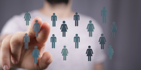 Close up of a hand touching figures representing people and concept of social media connections.