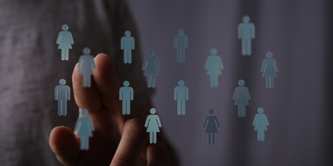 Hand touching network of people symbols, representing teamwork, communication and community. Visual...