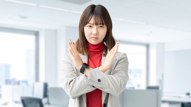 手でバツのポーズをする女性・ビジネスウーマン