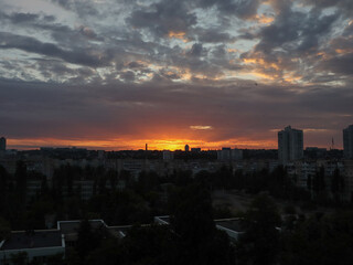 Dramatic sunset over city skyline with colorful clouds and buildings. The vibrant colors of the sunset illuminate the city, creating a stunning and memorable scene