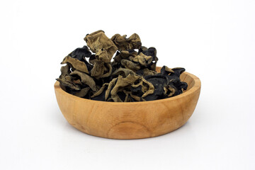 Dried asian mushrooms auricularia polytricha on the wooden bowl, isolated on white background. Auricularia polytricha, or black fungus, offers benefits such as supporting heart, liver, and gut health.