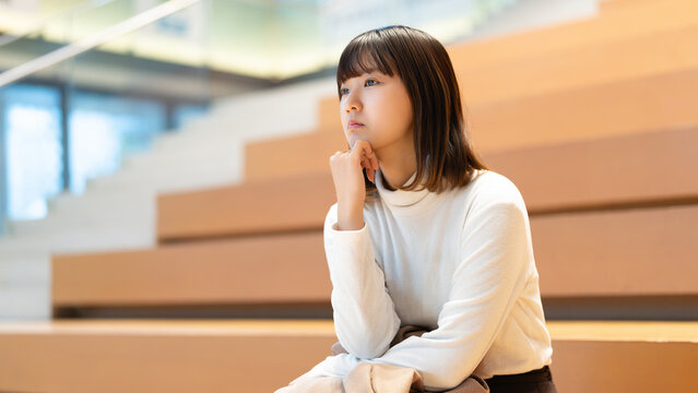 考えごとをする若い女性・ビジネスウーマン