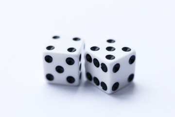 Two white dice with black dots on a white background. Close-up.