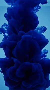 Detailed slow-motion shot of heavy organic dark blue ink spreading and expanding mesmerizingly through clear water creating beautiful abstract textures smoke effect, ink in water, maximal background
