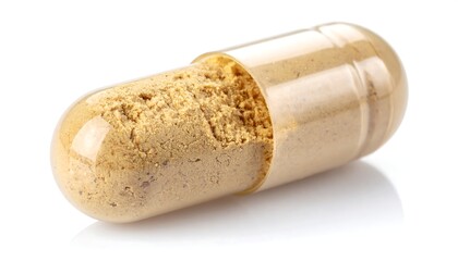 Tan capsule with powder, resting on its side on a reflective surface, illuminated against a plain white backdrop