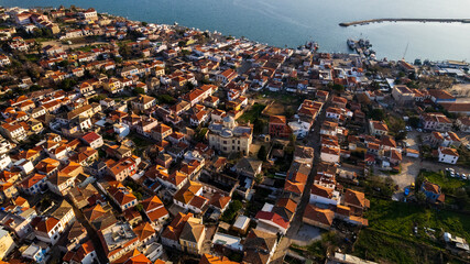 Aerial view of the historical Cunda Island town center with red-tiled stone houses and a coastal church in Ayvalik, Turkey