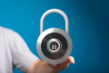 Close-up of a person's hand holding a digitally rendered padlock, symbolizing security, protection,...