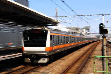 Fototapeta premium 駅を通過するスピード感のある中央線の電車