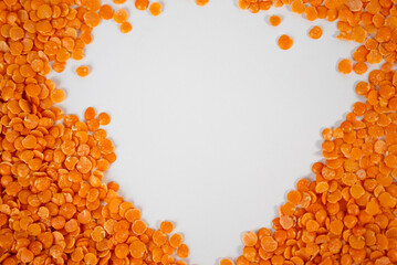 Top view of red lentils arranged in circular frame on white background. Perfect for healthy food, vegan cooking, and organic product advertising. 