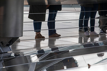 mirrored glass bridge with metal railings on a cloudy day